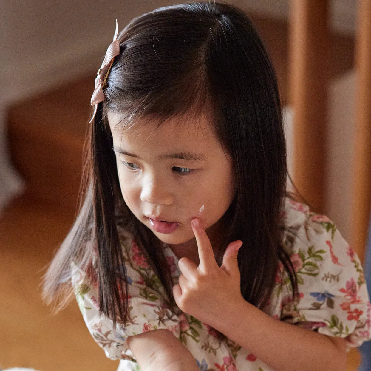 Child dabbing I-Got-You Cream onto her cheek