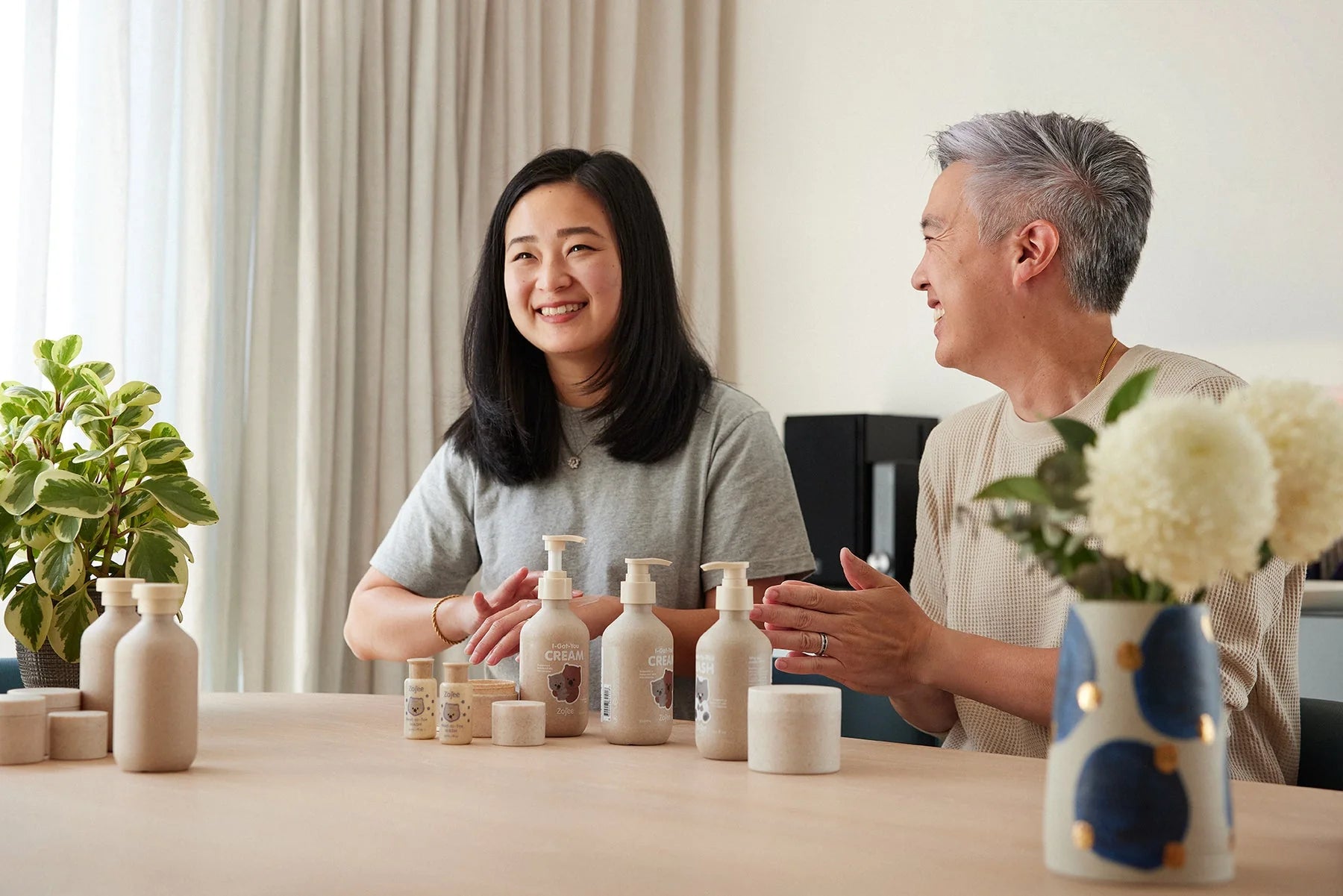 Jon and Alicia at a table with their daughter and Zojee products