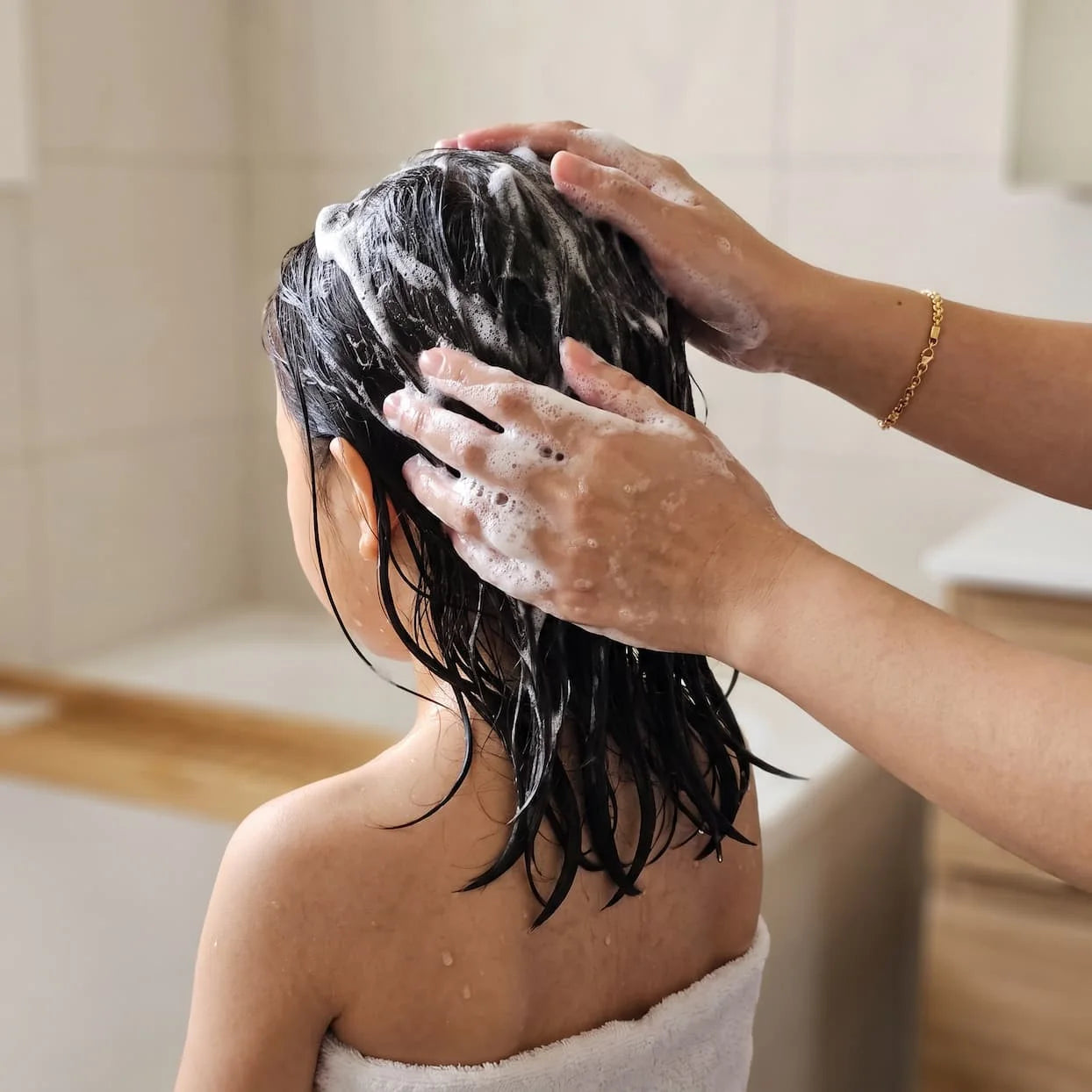 Lathering Head-to-Toe Wash through a child’s hair